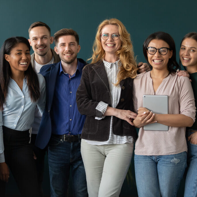 Portrait,Of,Standing,In,Row,Smiling,Team,Embracing,Looking,At educators