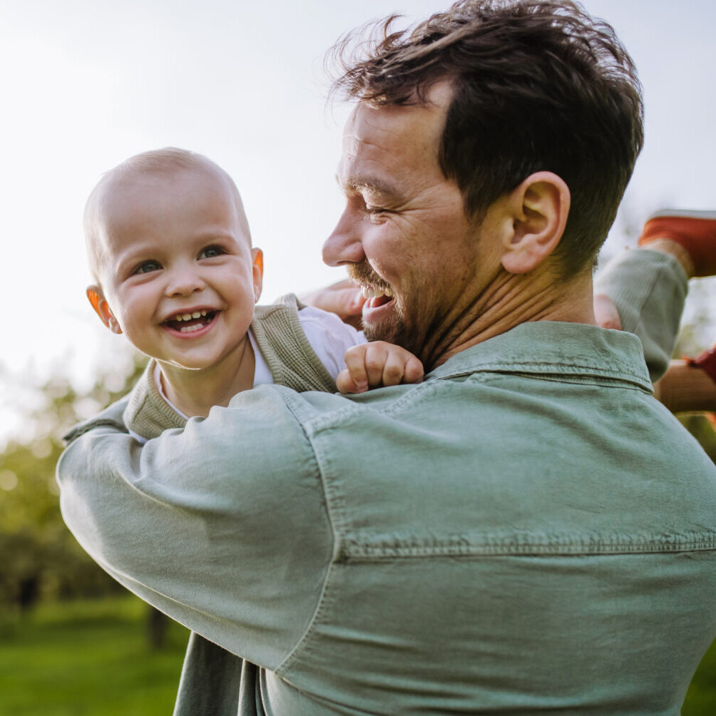 Father,Holding,Little,Baby,,Playing,,Having,Fun,During,Warm,Spring Father holding little baby, playing, having fun during warm spring day. Father's day concept.